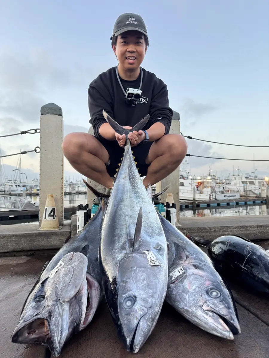 Hao on top of the closed Hao2Fish 30QT Tackle Box on the dock, with the trip's bluefin tuna laid out in front of it